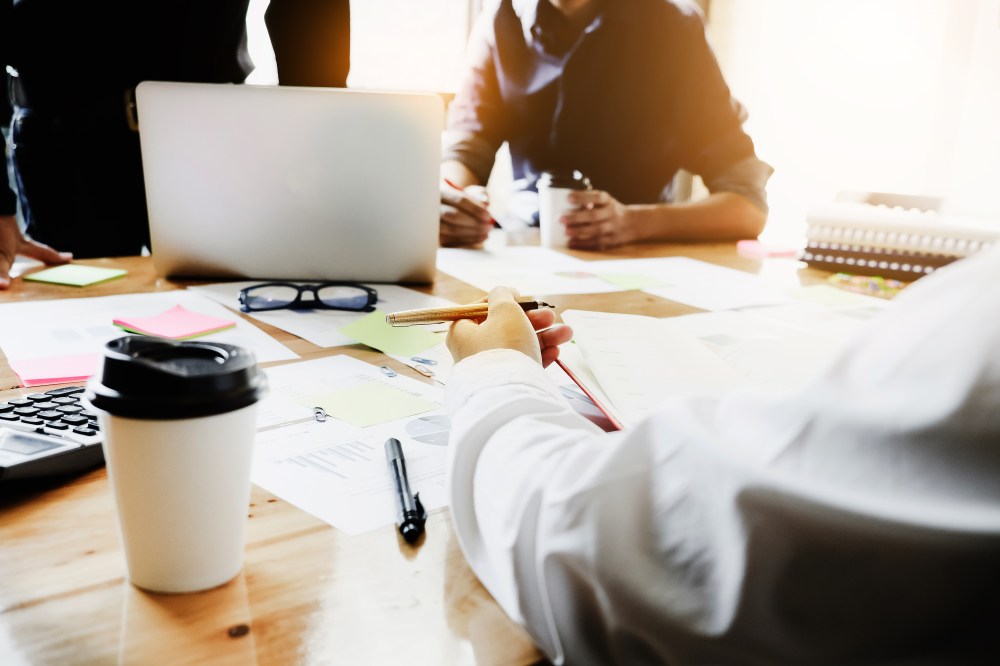 business people meeting in office, businesswoman holding pen and partner use laptop computer on wood desk for Plans to marketing improve quality next year.